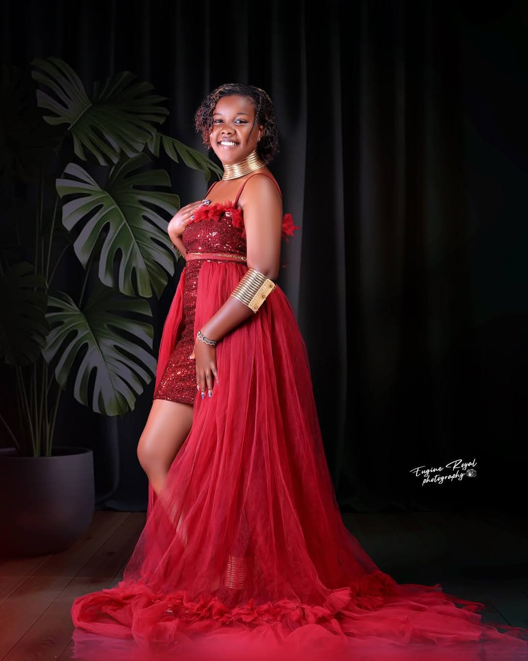 Birthday portrait of a woman in a red tulle gown in a dark studio set