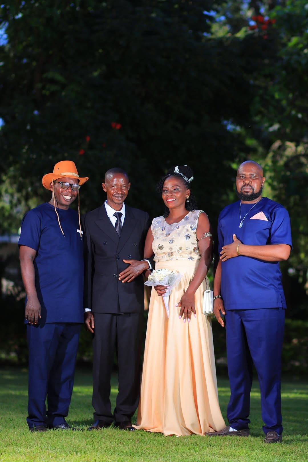 Bride and groom flanked by two guests in royal blue outfits