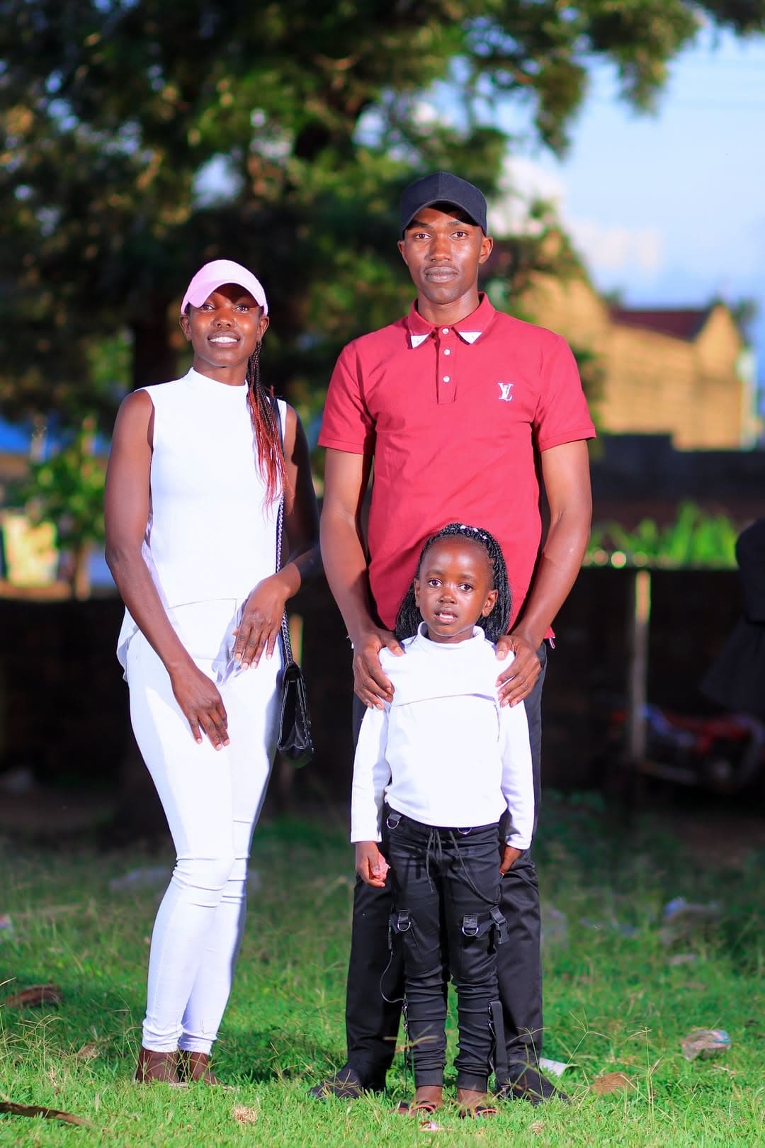 Family of three posing together on the lawn