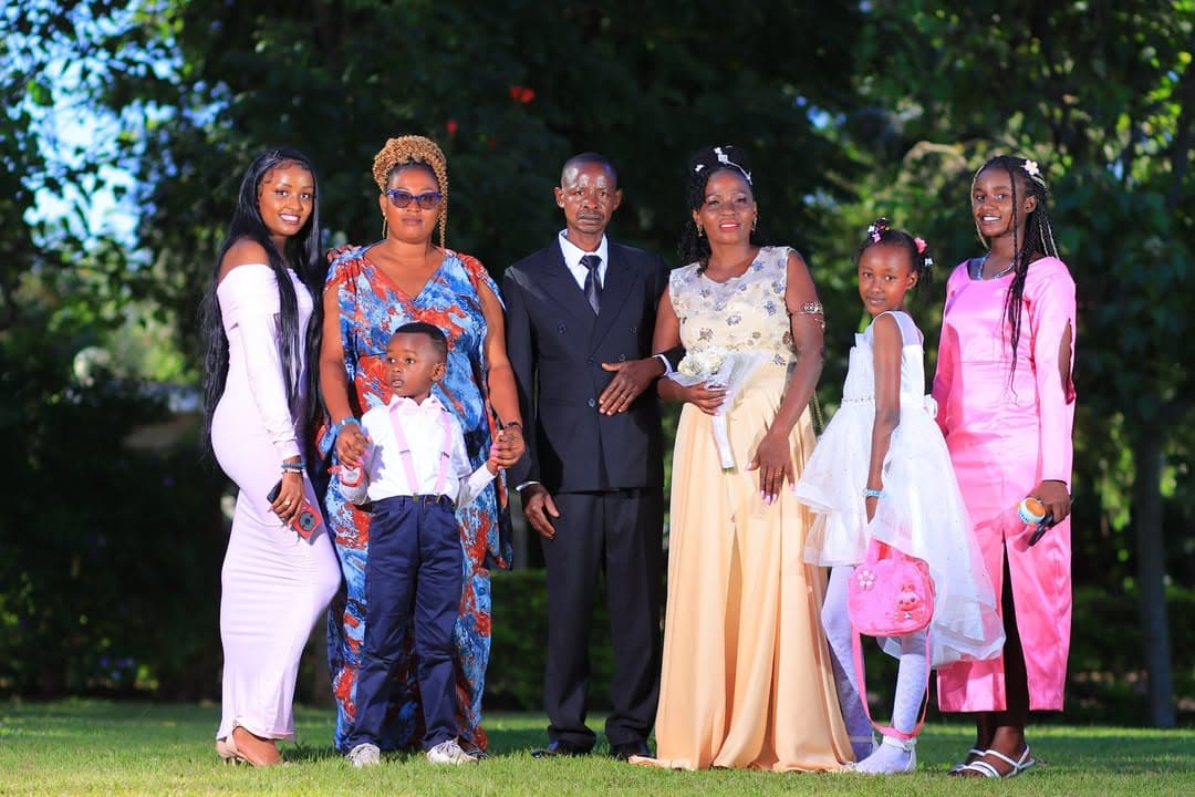 Large family group gathered around the couple on the lawn