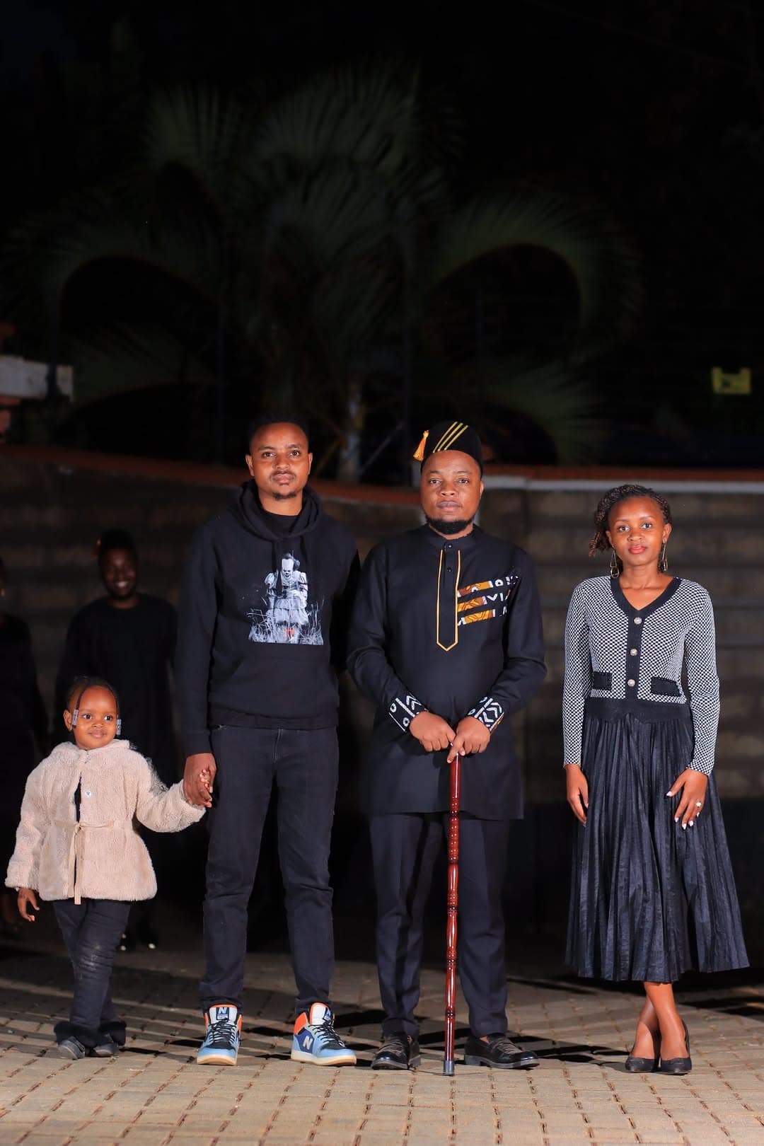 Family with a young child posing together at night