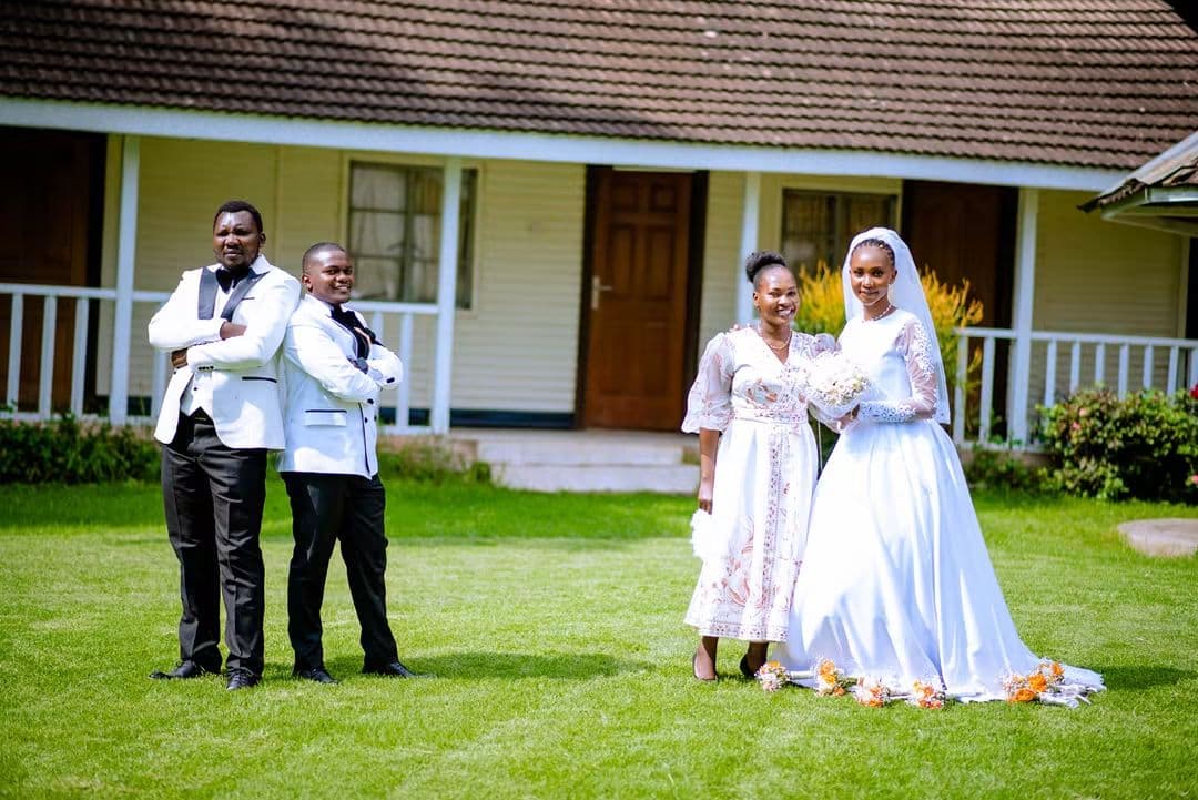Groom, best man, bride and maid of honour posing in front of a cottage