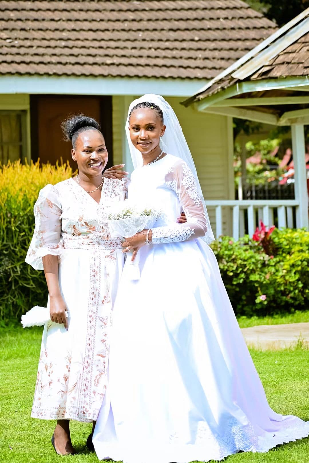 Bride and her maid of honour smiling together in the garden