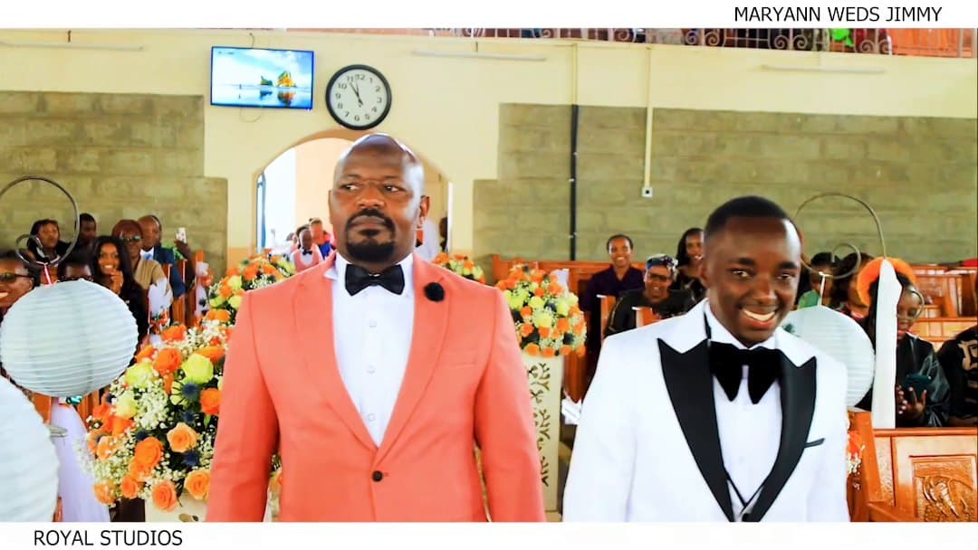 Groom and best man smiling in church, from Maryann and Jimmy's wedding film